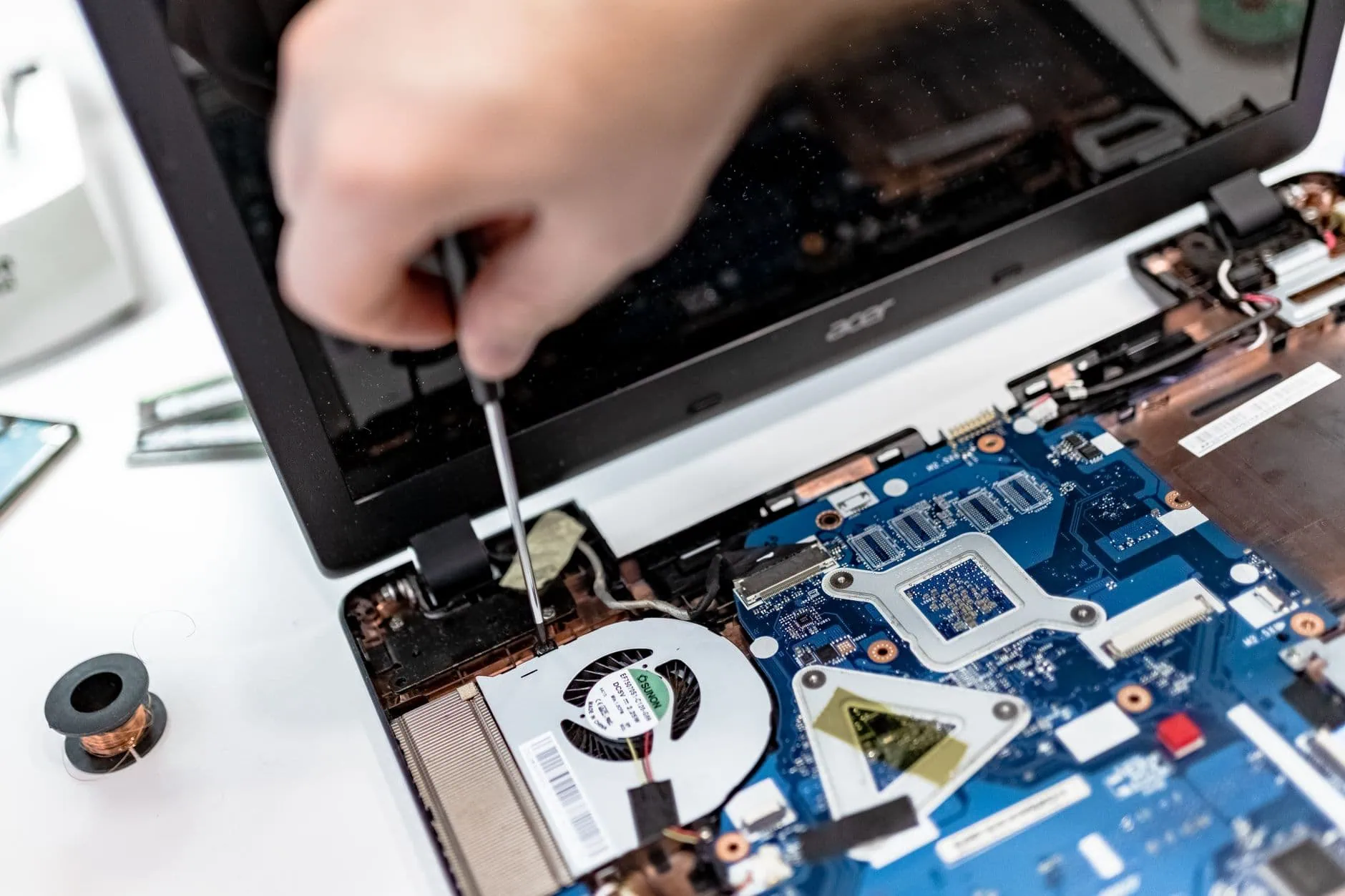 Comment éviter que votre Mac chauffe : 8 causes et solutions (Guide 2026) 1 Technicien intervenant sur la carte mère d'un ordinateur portable en atelier pour traiter une surchauffe