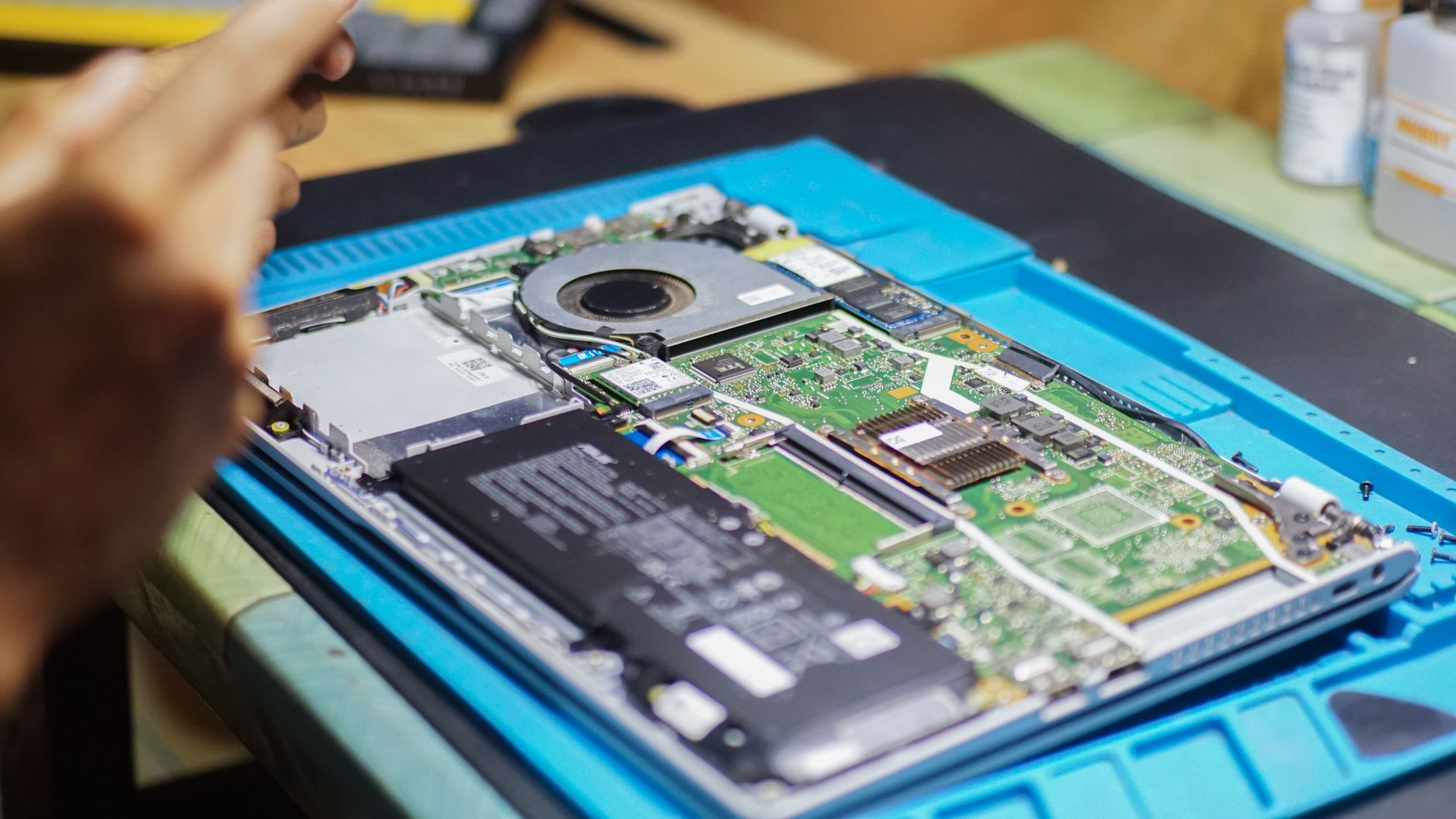 Impossible de faire la mise à jour de votre Mac ? 6 causes et solutions (Guide 2026) 2 Ordinateur portable ouvert en cours d'intervention en atelier, composants et outils visibles
